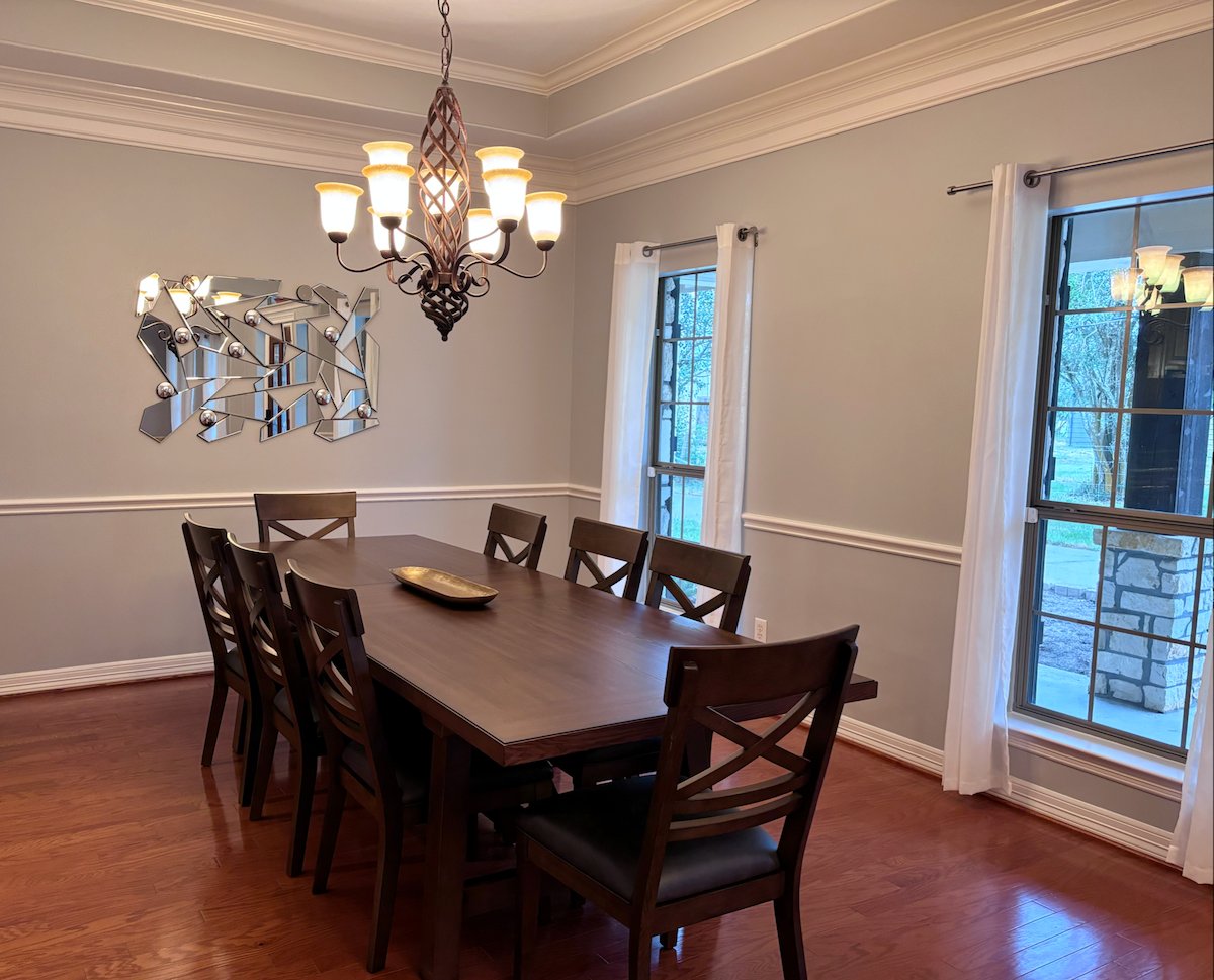 Formal dining room with large windows and 8-seat table